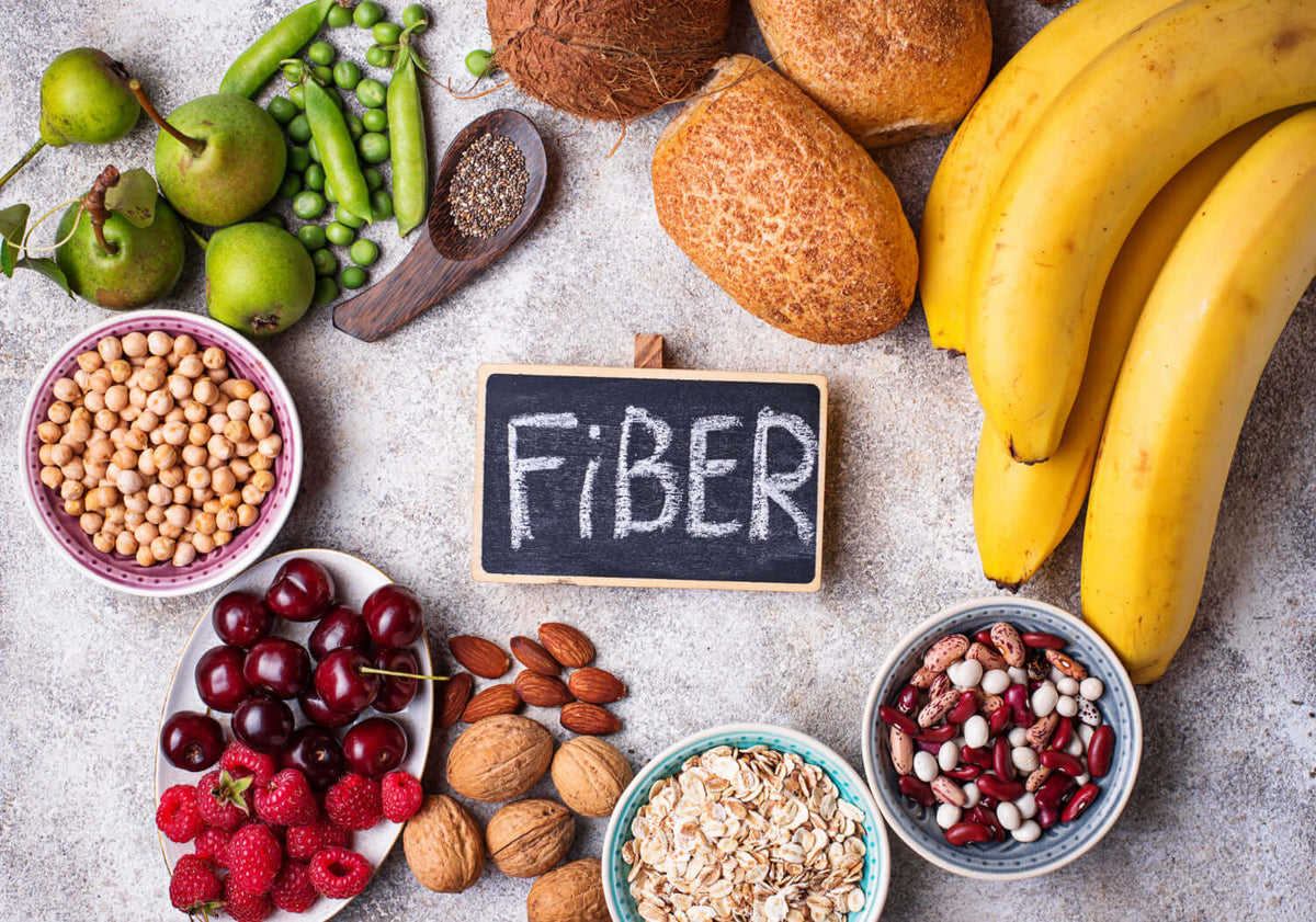 Colorful assortment of fiber-rich foods including fruits, nuts, and grains promoting gut health.