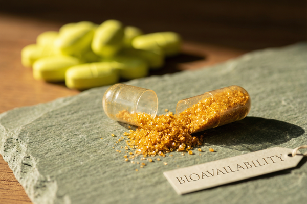 Activated B-Complex capsule spilling golden powder vs synthetic yellow tablets, illustrating vitamin bioavailability article image