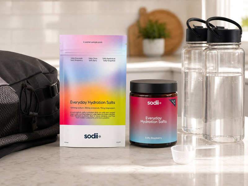 Electrolyte sachets and a tub compared beside water bottles and a day bag