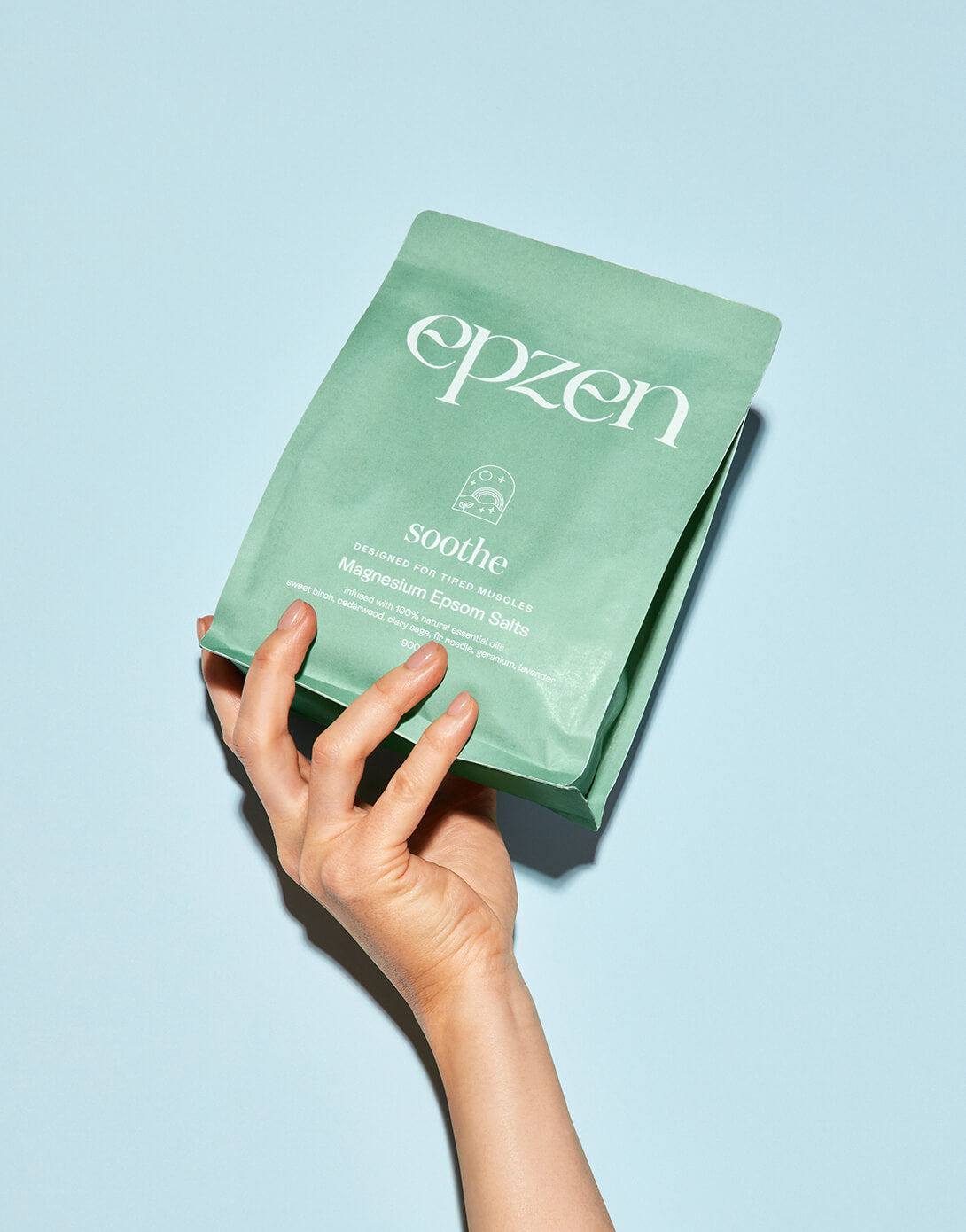 Epzen Soothe magnesium bath crystals pouch held in one hand