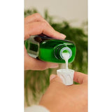 Weleda bath milk measured into the bottle cap