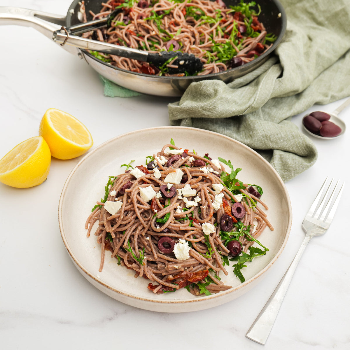 Serving suggestion: sorghum spaghetti with olives, tomatoes, rocket and vegan feta