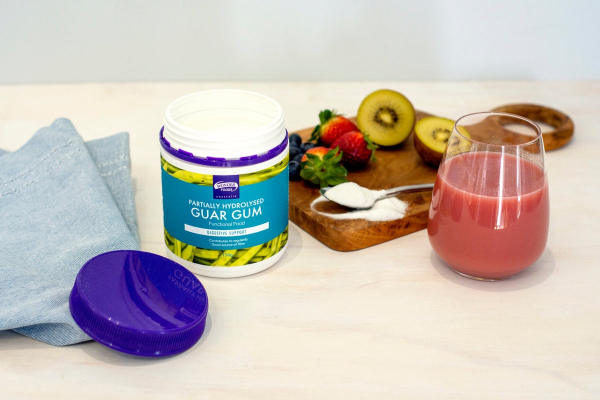 Wonder Foods PHGG powder beside a smoothie, fruit and a spoon, showing a serving idea